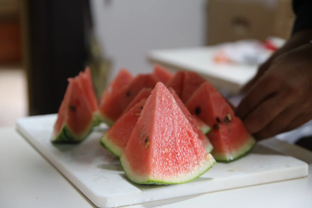 切り分けたスイカと食卓の手元（イメージ写真）